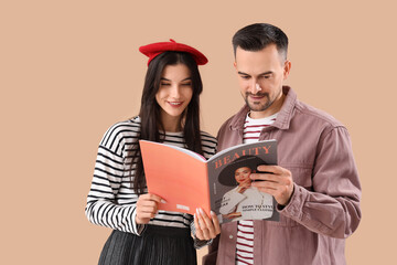 Poster - Young couple reading beauty magazine on beige background