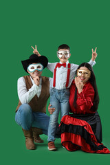 Poster - Happy family in costumes and carnival masks on green background