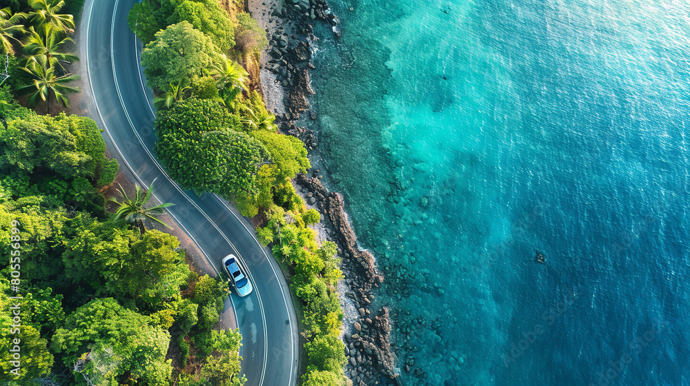 An aerial view of a coastal road trip, a sleek modern car driving along ...