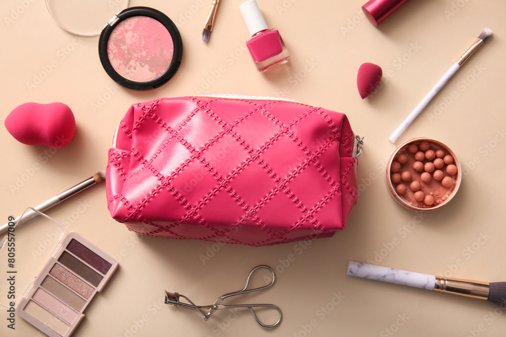 Pink cosmetic bag with makeup products and accessories on beige background