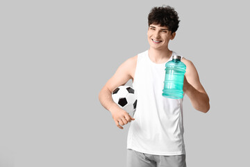 Canvas Print - Sporty guy with bottle of water and football ball on white background