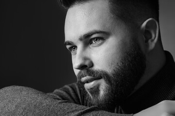 Canvas Print - Portrait of handsome bearded man on dark background. Black and white effect