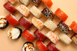 Tasty sushi rolls on beige background