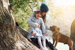 Female child, mother and playing in park with pet, trees and happiness in winter. Family, daughter and pitbull in nature for fun, bonding and free time in countryside for dog training outdoors