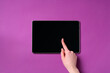 Online store. Woman using tablet on purple background, top view