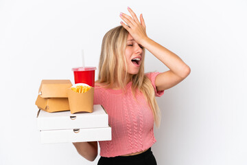 Wall Mural - Young caucasian woman holding fat food isolated on blue background has realized something and intending the solution