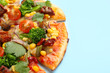 Delicious vegetarian pizza with mushrooms, vegetables and parsley on light blue background, closeup. Space for text
