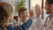 © Muhammad - Happy cute little boy giving high five to pediatrician, friendly doctor greeting preschool patient at medical appointment, good checkup result, young mum and son visiting gp in hospital
