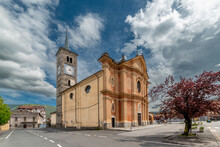 Paesana; Cuneo; Italy - 03 May 2024: The Parish Church Of Santa Maria In Piazza Vittorio Veneto In The Historic Village Under Spectacular Blue Skies With Large Clouds