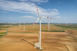 Aerial view of large wind turbines with spinning blades in the field