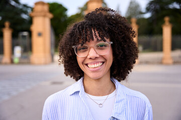 Close up head shot beautiful Latin American teen school girl single happy looking at camera. Wide and charming smile natural outdoor poses. Gen Z portrait concept. Cheerful young people. 