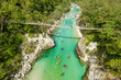 A suspension bridge spans the emerald waters of the Soca River in Slovenia