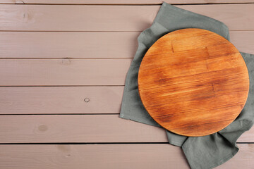 Wall Mural - Cutting board and napkin on beige wooden table, top view. Space for text