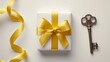 Key and gift box with yellow ribbon on white background