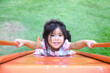 Happy face thai girl play slider in outdoor play park with energy
