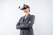 © InfiniteFlow - Businesswoman crossing arms while wearing VR glasses at white background. Skilled project manager checking at financial graph while using visual reality goggles. Innovation technology. Contraption.