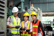 © Stella - Group of male and female industrial engineer workers with helmet and safety vest inspecting engine at manufacturing plant industry factory. Worker working with machinery machine in industry workplace.
