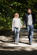 © peopleimages.com - Couple, holding hands and walk in park with love on date for relationship and bonding with smile. People, walking and outdoor with happiness in nature with partnership, conversation and care
