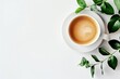 Elegant white cup of coffee with fresh green leaves on a white background