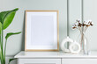 Mockup photo frame on the white wooden cabinet with house plants