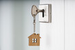 Room key and a house-shaped keychain. An open door. Real estate investment concepts