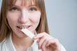 Young woman with metal braces on her teeth is chewing gum. Copy space. 