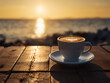 cup of coffee on wooden table on the seaside sunset