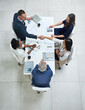 © peopleimages.com - Above, business people and handshake in office meeting for partnership, collaboration and corporate deal. Workplace, boardroom or team with hand gesture for agreement, new project or working
