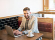 Businessman, laptop and portrait in coffee shop for happy, email and communication with client. Freelance male writer, technology and remote work in cafe for ebook, planning and idea for story