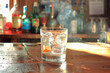 © yaqui_villegas - A single whiskey glass sits on a wooden bar, illuminated by the warm glow of sunlight, showcasing a tranquil, inviting ambiance