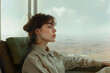 © yaqui_villegas - The image displays a woman looking through a large window at a vast mountainous landscape, representing wanderlust and the yearning for nature