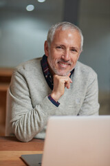 Canvas Print - Laptop, businessman and portrait in workplace with smile, pride and working at night for project. Happy, corporate and senior male person in workplace for online, email and commitment to company