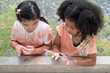 Little girls washing hands with soap at an outdoor faucet after activity outdoor painting watercolor at school. Kids hygiene and health concept.