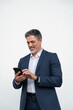 © Stock 4 You - Mature businessman in suit holding cellphone isolated, white background. Smiling 40s Latin business man using smartphone mobile phone screen device, scrolling app, working for communication. Vertical