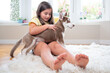 Smiling girl and her Siberian Husky puppy on carpet at home. High quality photo