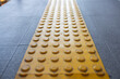 yellow tactile tiles are installed on outdoor pedestrian walkways to provide tactile ground surface indicators, aiding individuals who are blind or visually impaired.