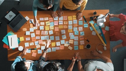 Top view of manager looking at idea on sticky notes and explain idea about web design. Skilled marketing team or programmer brainstorming idea while looking at tablet with color palette. Symposium.