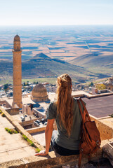 Wall Mural - Tourist woman enjoying old Mardin city panoramic view. Turkey