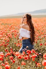 Canvas Print - Woman poppies field. Side view of a happy woman with long hair in a poppy field and enjoying the beauty of nature in a warm summer day.