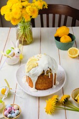 Wall Mural - Cake with lemon filling and poppy seeds, covered with sugar icing, on a ceramic plate on a light concrete background. Baking recipes with poppy seeds.