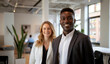 © BrightSpace - A man and a woman are smiling for the camera in a business setting. The woman is wearing a white jacket and the man is wearing a black jacket