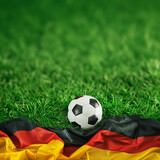 Fototapeta  -  Soccer ball sunset with german flag at the soccer field - Football in the sunset.