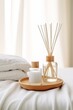 Aromatherapy reed diffuser, bottle with cream, white towels, spa salon banner