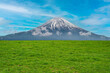 Panoramic view of lush grass on the green field in front of Fuji mountain, Japan.
