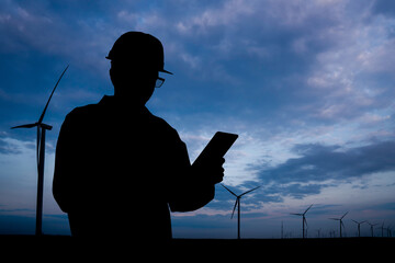 Aufkleber - Silhouette of engineer with tablet computer and wind turbines at sunset.