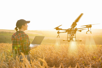 Poster - Woman farmer controls drone sprayer with a tablet. Smart farming and precision agriculture.
