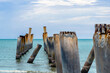 Beautiful view of leaning pillars of the old pier. Slanted concrete pole beach. Abandoned fishing pier pillar by the sea. Many of old concrete pillars were left on beach by the sea. Selective focus.
