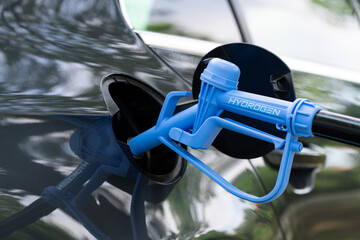 Wall Mural - Close up of fuel cell car with connected hydrogen fueling nozzle.