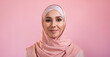 © golubovy - Islamic woman portrait. Muslim beauty. Happy confident smiling pretty female face in hijab headscarf isolated on pink empty space background.