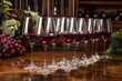 A row of elegant red wine glasses neatly arranged on a wooden table